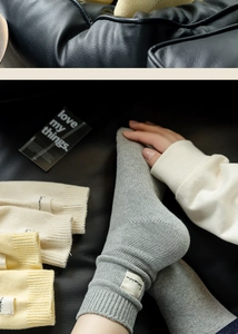 Detailed close-up of ribbed cotton socks in neutral tones on a leather background