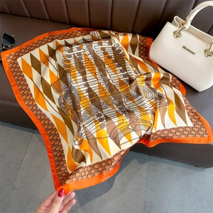 Diamond chain print silk satin square scarf displayed on leather sofa with fashion props
