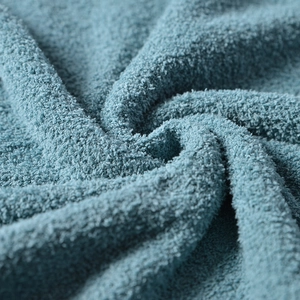 Macro shot of soft teal knitted fabric showing premium microfiber loops and texture