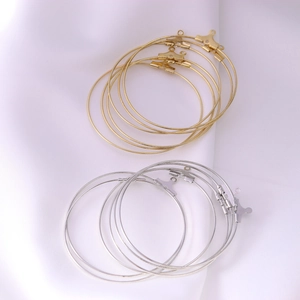 DIY round metal hoop earring components in gold and silver finish on white fabric