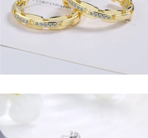 Macro view of gold chain earrings featuring cubic zirconia pavé stones on white card
