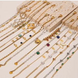 Detailed close-up of vintage gold bracelets with natural stones, pearls and butterfly charms