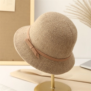 Elegant Audrey-style knitted sun hat with bow detail on a vintage display stand