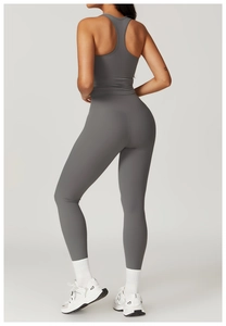 Detail of dark grey racerback sports vest and high-waist leggings on a female model