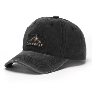 Detail of washed cotton baseball cap featuring embroidered mountain patch and distressed brim