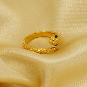 Adjustable golden snake ring with textured scales and green gemstone eyes on silk
