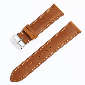 Detailed view of brown leather watch strap with white stitching and silver buckle