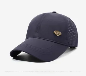 Detail of navy blue baseball cap featuring side ventilation holes and gold metal logo