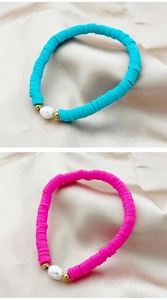 Detail of pink and blue bohemian Heishi clay bracelets with natural baroque pearls
