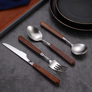 Walnut handle 304 stainless steel cutlery set including knife, fork and spoons on rock surface