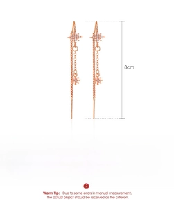 Detail view of rose gold tassel earrings with moon and star, 8cm long, made of copper