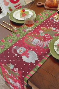 Detail of Christmas table runner featuring snowmen and gingerbread men on a wooden table