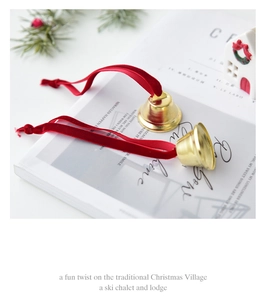 Golden Christmas bell ornaments with red velvet bows on decorative holiday background