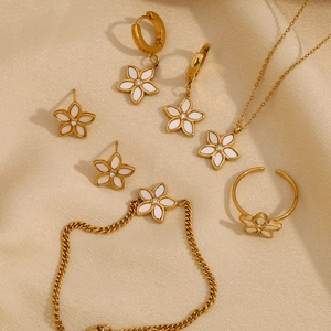 Exquisite 18K gold plated jewelry set with white floral charms on beige silk fabric