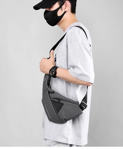 Detail of water-resistant dark grey crossbody sling bag with triangular zipper pocket