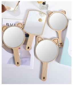 Detailed view of wooden handheld mirrors with animal ears on a minimalist vanity setup