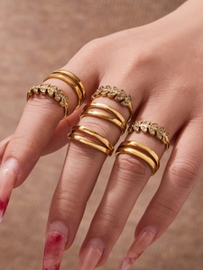 Close-up of leaf and olive branch rings with zircons on a natural linen background