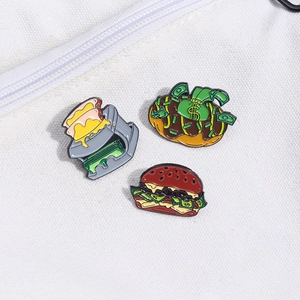 Detailed close-up of creative enamel pins featuring money-filled food and toaster designs