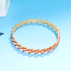 Detail of magic stretchable ring bracelet in gold finish with sparkling red rhinestones