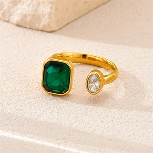 Detail of 18K gold-plated ring with emerald-cut green stone and oval crystal accents