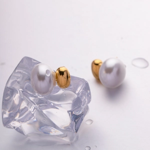 Elegant French vintage gold pearl earrings on ice prop with water drops background