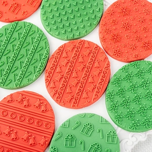 3D Christmas cookie stamps featuring snowflake, tree and candy cane patterns on fondant