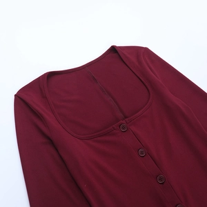 Close-up of wine red knitted jumpsuit featuring a square neck and button details