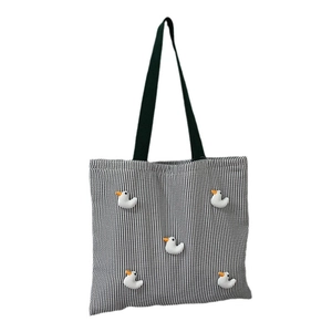Black and white striped canvas tote bag with 3D duck decorations and green handles
