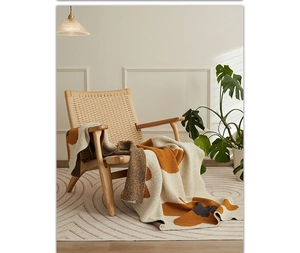 Close-up of Nordic style knitted throw blanket with sunflower patterns on a wooden chair