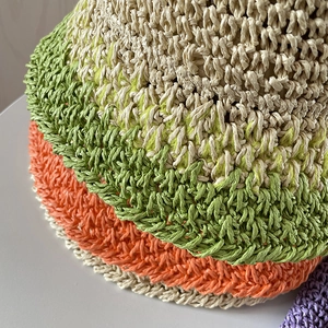 Dettaglio ravvicinato del cappello di paglia intrecciato a mano con trama all'uncinetto colorata