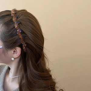 Brown woven headband with colorful accents on wavy hair for a vintage autumn look