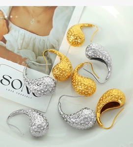 Detailed view of teardrop earrings with hammered texture in gold and silver finish