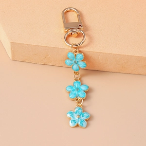 Detailed close-up of blue enamel cherry blossom charms with gold-plated spring clasp