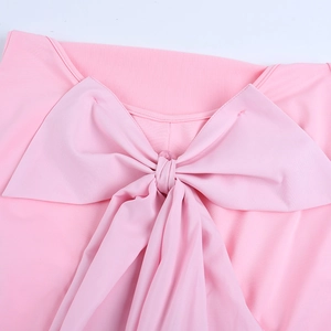 Close-up of a pink mini dress featuring a large bow detail and backless design