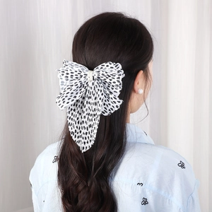Polka dot chiffon bow hair clip with pearls shown on model from the back view