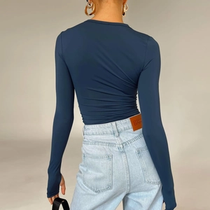 Detail of slim fit long sleeve top in navy blue featuring high elastic fabric and thumb holes
