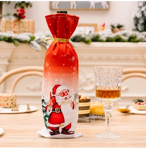 Detail of Christmas wine bottle cover with Santa Claus pattern and gold ribbon tie