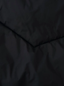 Detailed close-up of black quilted water-resistant fabric with neat stitching and diagonal folds