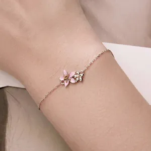 Minimalist S925 sterling silver cherry blossom bracelet with pink enamel flowers on a wrist