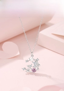 Detailed close-up of s925 silver crescent moon and butterfly pendant with pink stone