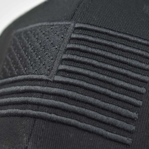 Distressed black cotton baseball cap with embroidered US flag patch, front view