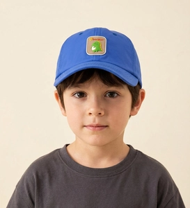 Close-up of bright blue kids baseball cap featuring a cute cartoon dinosaur embroidery patch