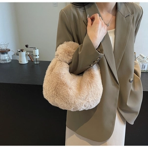 Sac à main chic en peluche beige porté par un mannequin dans un café automnal