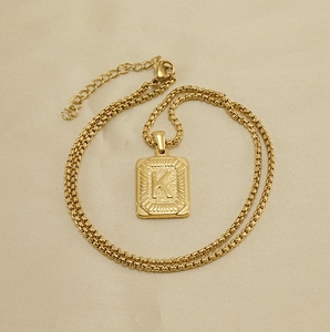 Detailed view of 18K gold plated square pendant with embossed letter K on box chain