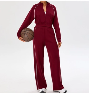 Detail of burgundy two-piece tracksuit with contrast white piping and zip-up collar