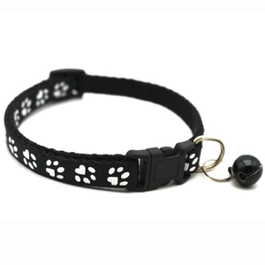 Close-up of black pet collar with white paw prints featuring a bell and buckle
