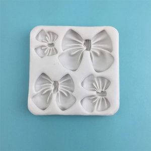 White silicone mold with four bow cavities for chocolate and fondant DIY crafts