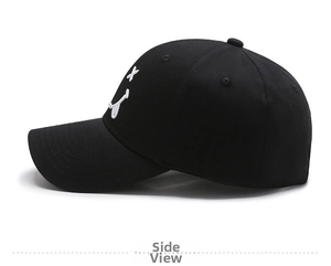 Side view of black cotton baseball cap with white embroidered smiling face on a white background