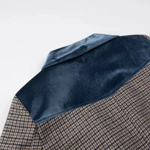 Détail du col en velours bleu et du motif pied-de-poule marron de la veste