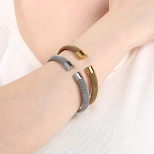 Dettaglio di bracciali aperti a maglia intrecciata oro e argento con trama metallica